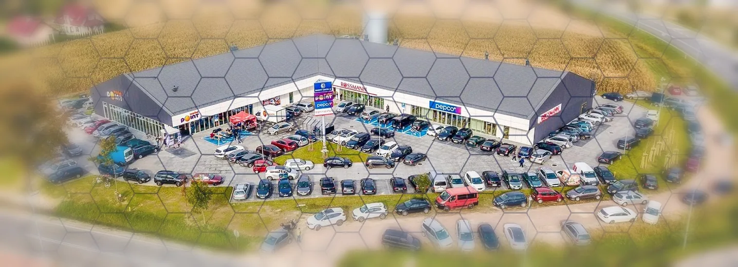 Aerial view of a commercial retail park divided into a hexagonal blockchain grid - one property, many token holders